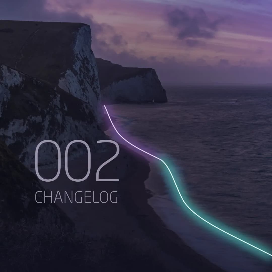 Changelog 002: chalk cliffs above a curved beach at dusk, with the newest wave glowing